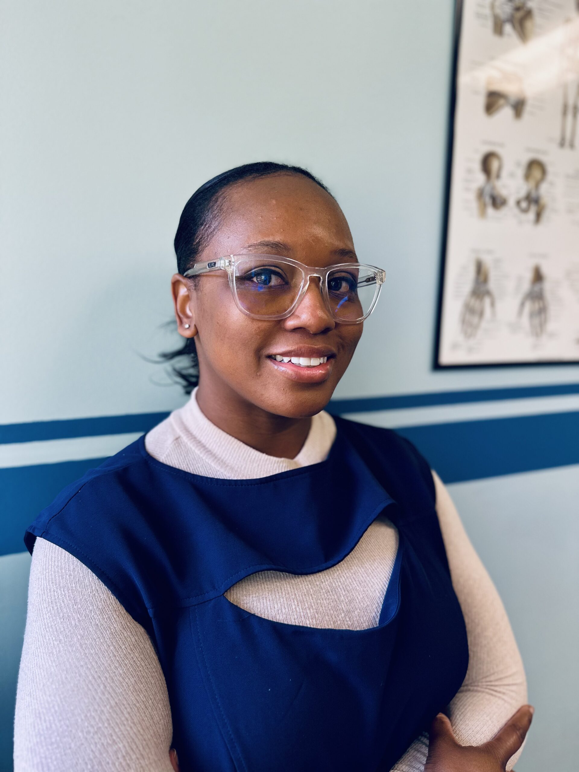 Brianna at TriLumos Physical Therapy next to Joint poster.